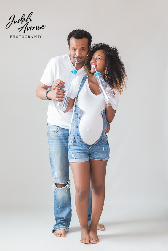 Premium Photo | A pregnant woman and a man in a white shirt and jeans in a  studio on a black background.